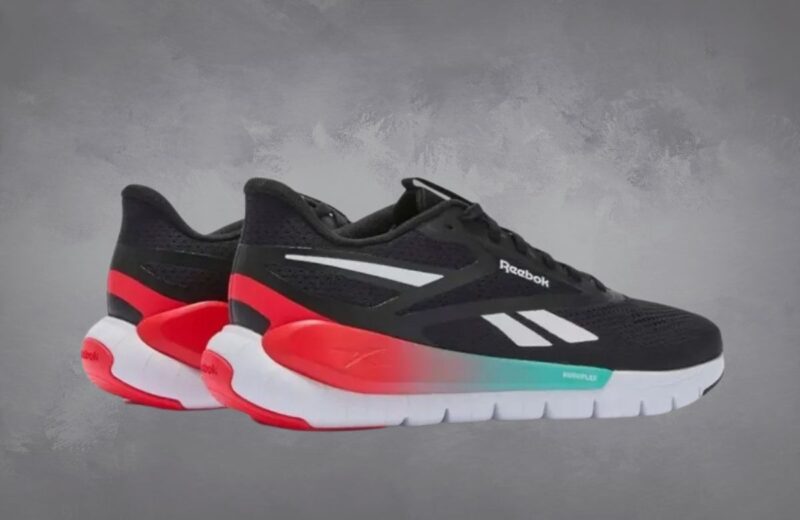 Crne Reebok Flex Trainer patike sa belim đonom i crveno-tirkiznim detaljima, dizajnirane za udobnost i lakoću tokom vežbanja